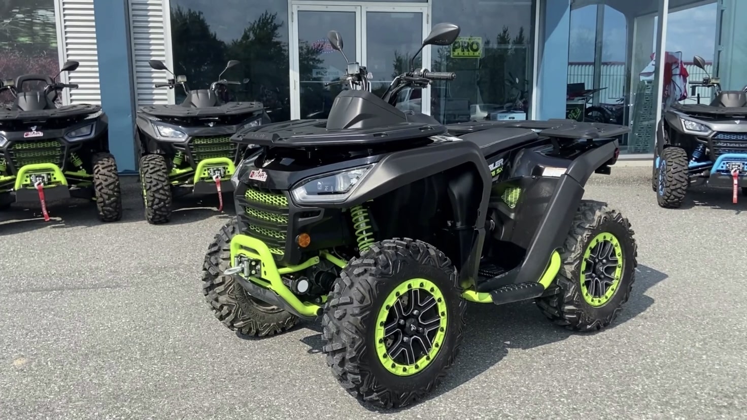 Several black and green Snarler AT6 Segway ATVs on display outside a store.