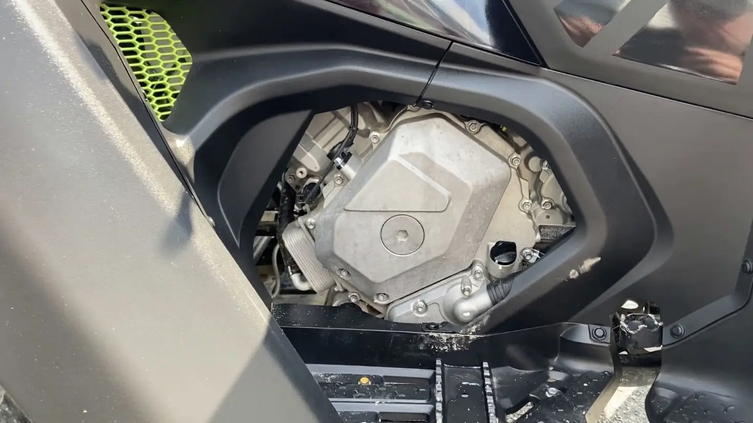 Close-up view of the engine of a Segway AT6 Snarler ATV with black fairing and green detailing.